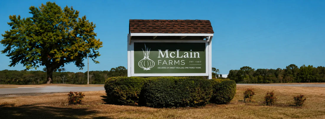 A sign in a field surrounded by hedges, on which the label reads “McLain Farms, Decades of Sweet Vidalias, One Family Name.”